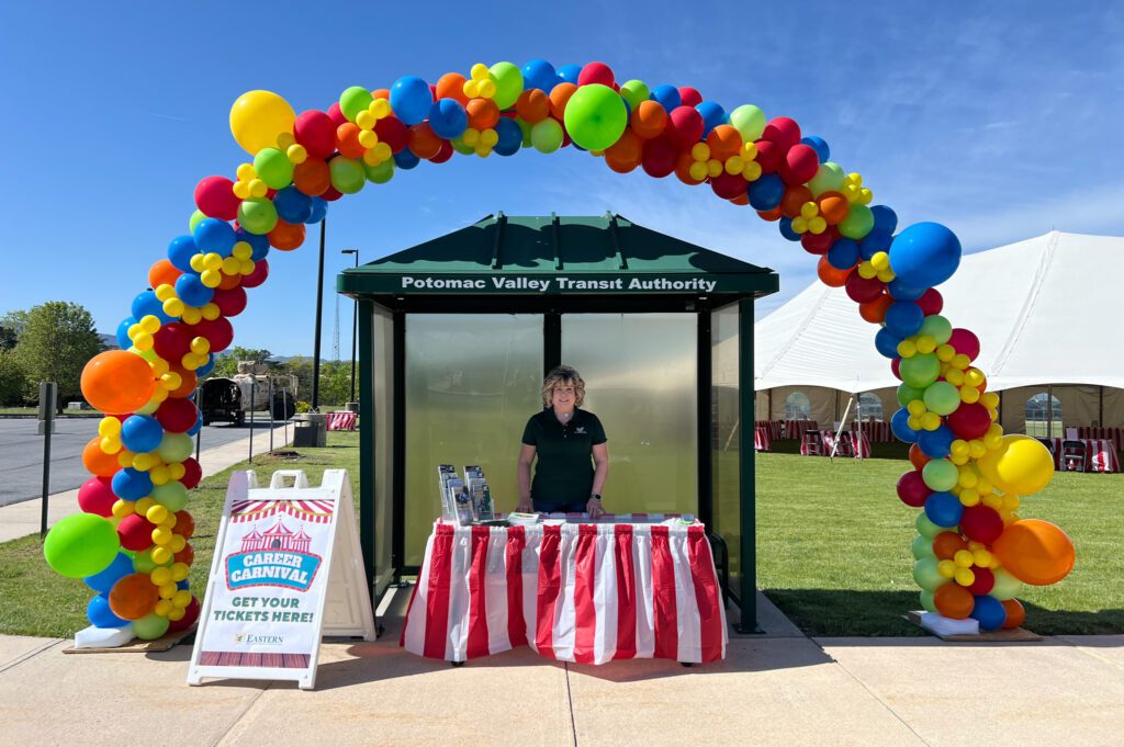portrait of a woman under a balloon arch.