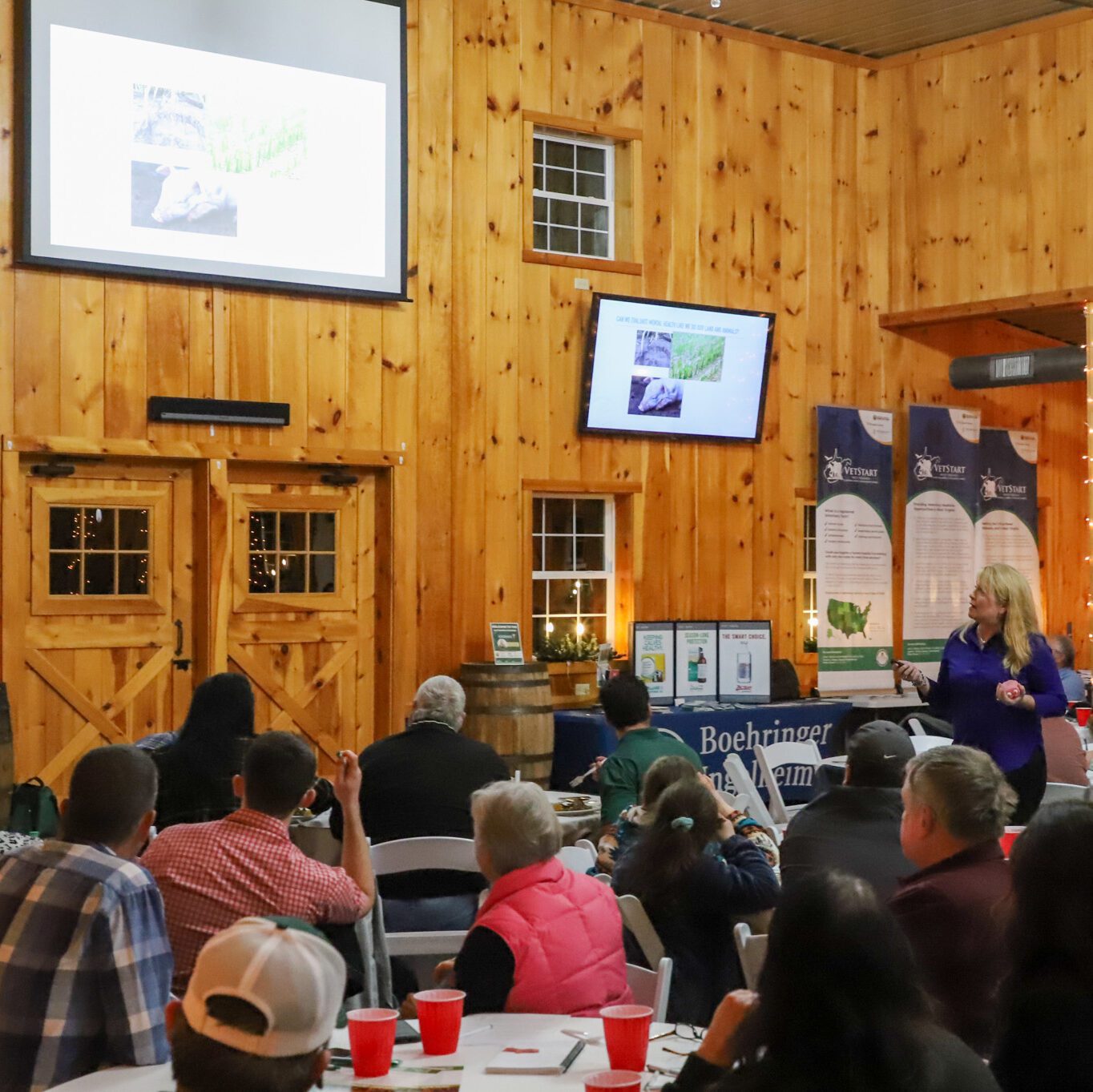 Woman speaker presenting to room full of people
