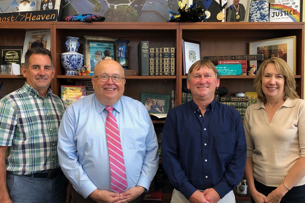 From left, standing against bookcase, arePhillip Douthitt, Dr. Chris Gilmer, Dr. Tom Striplin, and Beth Little