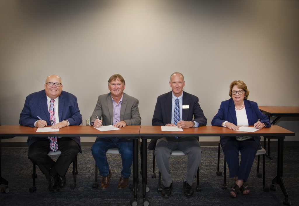 Photo of three men and one woman (President's of respective colleges)
